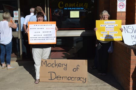 Protestors outside of the Harden Country Club this morning before the commencement of the Harden public Inquiry into the Harden, Boorowa, Young merger proposal.